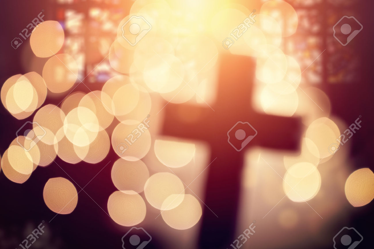 54427916-Abstract-defocussed-cross-silhouette-in-church-interior-against-stained-glass-window-concept-for-rel-Stock-Photo